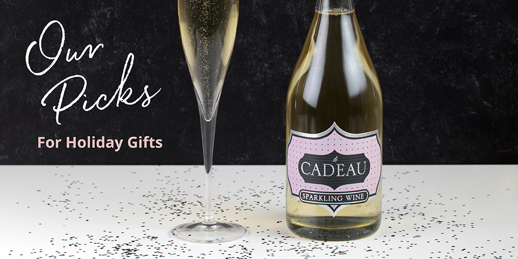 Bottle of sparkling wine, wine glass, confetti and the words "Our Picks for Holiday Gifts"