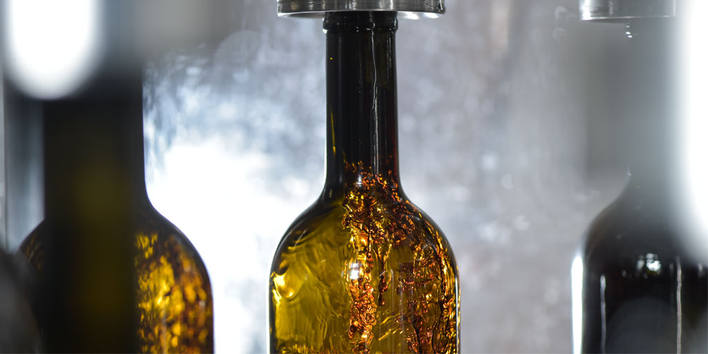 Wine bottle close-up, being filled with wine on bottling line