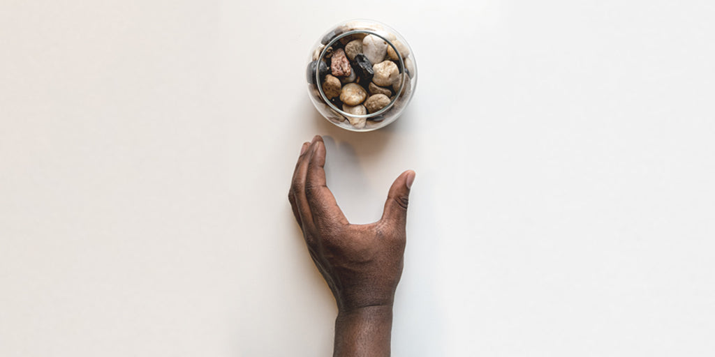 Pebbles in a glass with a hand