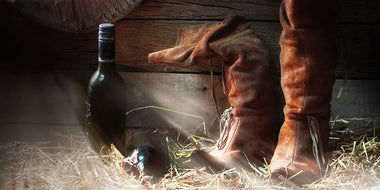 Wine and cowboy boots in a barn