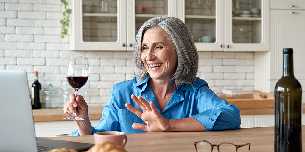 Woman enjoying wine while on laptop