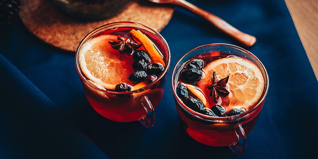 Two glasses with a hot drink mulled wine on a dark tablecloth