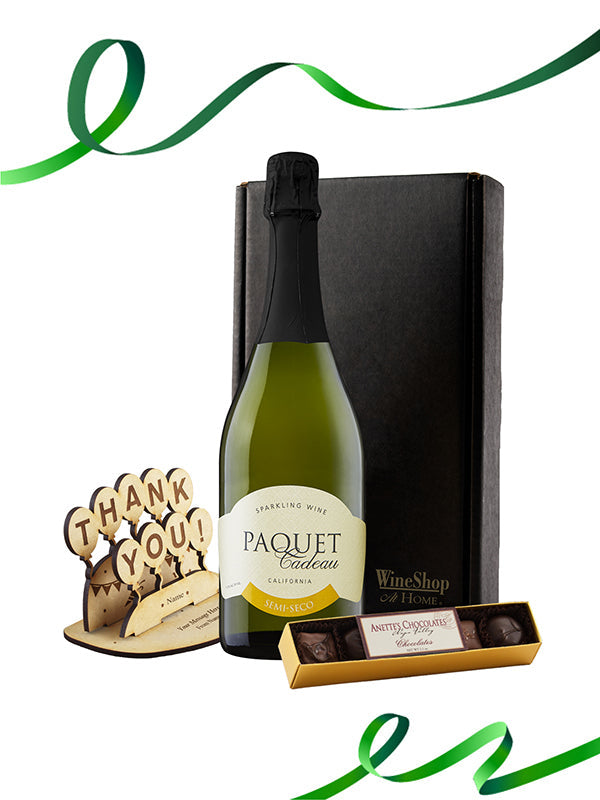 Wine bottle with a box, wooden coaster, and chocolate bar on a white background