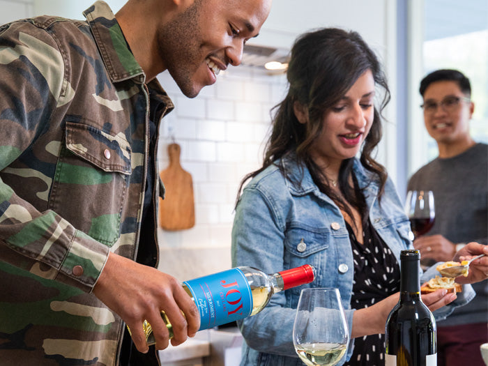 Friends in kitchen drinking and enjoying wine