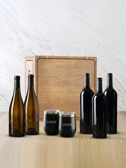 5 bottles of wine, 2 black stemless tumblers with "LOGO" text on them, in front of a wood crate box