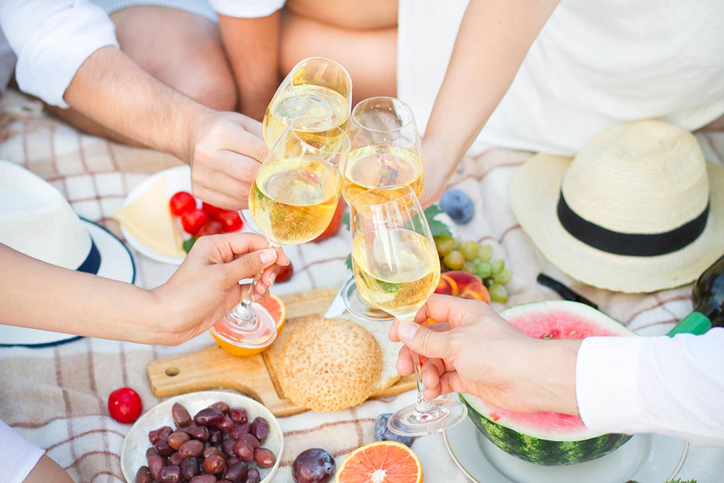 Crowd-Pleasing Tasting Themes - outdoor picnic with people cheersing