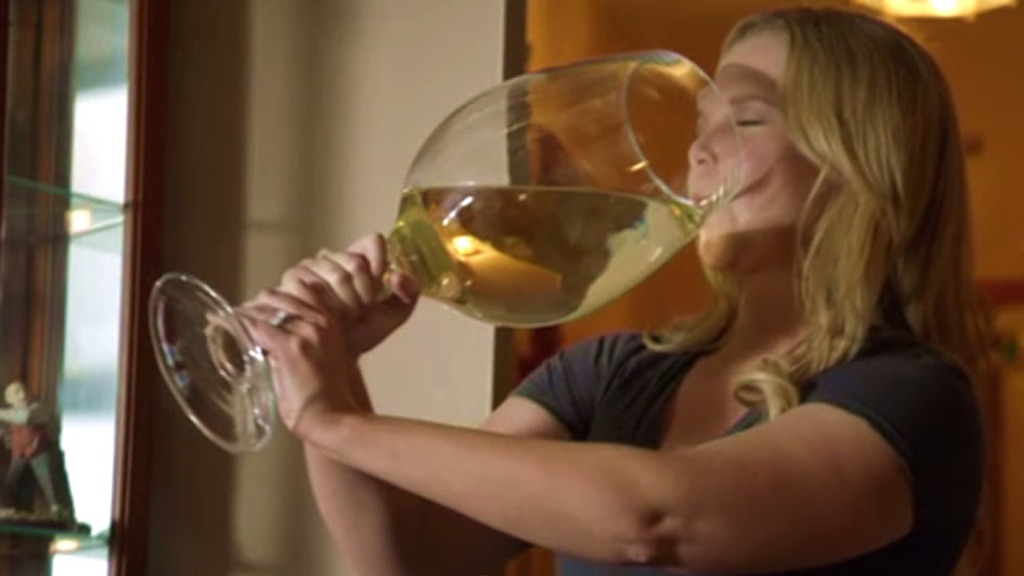 Amy Schumer drinking a large glass of wine